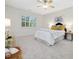 Bright bedroom with a plush bed, ceiling fan and natural light from a large window at 102 Westside Dr, Chapel Hill, NC 27516