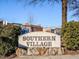 Entrance sign for Southern Village, set against a backdrop of mature trees and neighborhood buildings at 102 Westside Dr, Chapel Hill, NC 27516