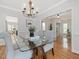 Well lit dining room with a view of the living room, hardwood floors, and a glass dining table at 102 Westside Dr, Chapel Hill, NC 27516