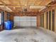 Spacious garage interior with a white door, concrete floor, exposed wood framing, and ample storage space at 102 Westside Dr, Chapel Hill, NC 27516