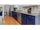 Modern kitchen features stainless steel appliances, blue cabinets, and tile backsplash at 102 Westside Dr, Chapel Hill, NC 27516