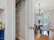 Pantry featuring wire shelves, adjacent to a dining room with a glass table set and abundant natural light at 102 Westside Dr, Chapel Hill, NC 27516