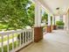 Covered front porch featuring classic columns, ceiling fan, and views of the neighborhood at 102 Westside Dr, Chapel Hill, NC 27516