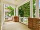 Spacious front porch with brick accents, white railings, and views of the landscaped yard at 102 Westside Dr, Chapel Hill, NC 27516