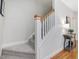 Carpeted staircase with white railings and wooden accents leads to the upper level at 102 Westside Dr, Chapel Hill, NC 27516
