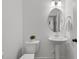 Clean, minimalist bathroom with pedestal sink, oval mirror, and a neutral color scheme at 1028 Gallivant Way, Wake Forest, NC 27587
