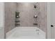 Ceramic tiled bathtub with mounted shower head, soap shelves and window at 1028 Gallivant Way, Wake Forest, NC 27587