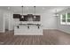 Bright kitchen with granite counters, an island with seating, and modern pendant lighting at 1028 Gallivant Way, Wake Forest, NC 27587