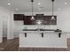 Stylish kitchen with a large center island, pendant lighting, and dark wood cabinets at 1028 Gallivant Way, Wake Forest, NC 27587