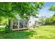 Spacious backyard with lush green grass, a screened-in porch, and a patio for entertaining at 103 Chapelwood Way, Cary, NC 27518
