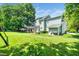 Expansive backyard with lush lawn, mature trees, and outdoor living spaces for relaxation at 103 Chapelwood Way, Cary, NC 27518