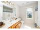 Well-lit bathroom featuring a window, tile flooring, and a vanity with ample counter space at 103 Chapelwood Way, Cary, NC 27518