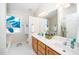 A modern bathroom featuring double sinks, wooden cabinets, and a stained glass window at 103 Chapelwood Way, Cary, NC 27518