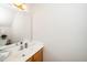 A well-lit half-bathroom with white countertops, a mirror, and a wooden cabinet at 103 Chapelwood Way, Cary, NC 27518
