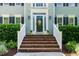 Inviting brick porch with white railings, decorative front door, and manicured landscaping at 103 Chapelwood Way, Cary, NC 27518