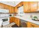 A well-maintained kitchen with wood cabinets, a white countertop, and modern appliances at 103 Chapelwood Way, Cary, NC 27518