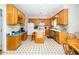Spacious kitchen with wooden cabinets, an island, and retro-style flooring at 103 Chapelwood Way, Cary, NC 27518