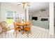 Bright living room with an adjacent breakfast nook and fireplace, featuring large windows and a ceiling fan at 103 Chapelwood Way, Cary, NC 27518