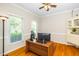 Bright office with hardwood floors, large windows, and built-in shelving unit for storage at 103 Chapelwood Way, Cary, NC 27518