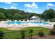 Community pool featuring many chairs and tables with decorative umbrellas for relaxation and social gatherings at 103 Chapelwood Way, Cary, NC 27518