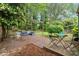 Lush backyard with brick patio, outdoor seating, a pergola, and mature trees at 109 Davidson Ave, Durham, NC 27704