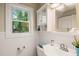 Bright bathroom with white vanity, decorative mirror, and a window offering natural light at 109 Davidson Ave, Durham, NC 27704