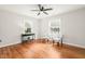 Bedroom with hardwood floors, ceiling fan, two windows, and console table with lamp and decor at 109 Davidson Ave, Durham, NC 27704