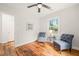Well-lit bedroom with hardwood floors, featuring two blue chairs and a side table at 109 Davidson Ave, Durham, NC 27704