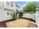 Charming backyard with pea gravel, brick pavers, a wooden fence, and lush greenery, creating a private outdoor space at 113 Spring Cove Dr, Cary, NC 27511
