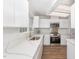 Well-lit kitchen with stainless steel appliances, white cabinets, and quartz countertops, creating a clean, modern look at 113 Spring Cove Dr, Cary, NC 27511