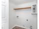 A small unfinished utility room featuring a shelf, wood-look flooring, and white walls at 113 Spring Cove Dr, Cary, NC 27511