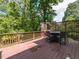 Back deck with chairs and a table featuring wood railing and lush trees at 124 Creekvista Dr, Holly Springs, NC 27540