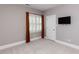 Cozy bedroom featuring a window with shutters and curtains, and a wall-mounted TV at 124 Creekvista Dr, Holly Springs, NC 27540