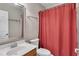 Bathroom with red shower curtain, sink, mirror, and wooden vanity provides essential amenities at 134 Riverwalk Cir, Cary, NC 27511