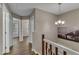 Hallway with wood floors, chandelier light fixture, and white trim creates an inviting path to rooms at 134 Riverwalk Cir, Cary, NC 27511