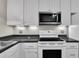 Close up of modern kitchen appliances including the microwave, oven and cooktop, and sleek countertops at 134 Riverwalk Cir, Cary, NC 27511