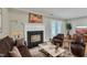 Living room features brick fireplace, seating, wood flooring, and access to backyard at 134 Riverwalk Cir, Cary, NC 27511