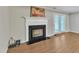 Living room with fireplace, white mantle, and sliding doors to backyard at 134 Riverwalk Cir, Cary, NC 27511