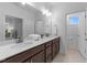 Bathroom featuring dual vanities with wood cabinets, a large mirror, and modern lighting fixtures at 143 Swain St, Clayton, NC 27527