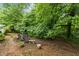 Serene backyard featuring a brick-paved area with seating amidst lush trees, offering a tranquil outdoor retreat at 1503 Laughridge Dr, Cary, NC 27511