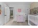 Charming Bedroom with pink changing table, open doors, and view into adjacent rooms, providing a spacious feel at 1503 Laughridge Dr, Cary, NC 27511