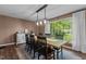 Bright dining room featuring a large window overlooking the backyard and a rustic table with seating for six at 1503 Laughridge Dr, Cary, NC 27511