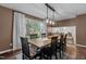 Bright dining room featuring a large window overlooking the backyard and a rustic table with seating for six at 1503 Laughridge Dr, Cary, NC 27511