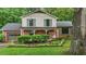 Charming two-story home featuring a brick exterior, green shutters, mature landscaping, and inviting front porch with swing at 1503 Laughridge Dr, Cary, NC 27511