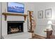 Living room featuring a brick fireplace with wooden mantle, mounted television, and tasteful decor at 1503 Laughridge Dr, Cary, NC 27511