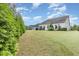 Spacious backyard with manicured lawn and mature trees at 1528 Anthology Dr, Durham, NC 27703