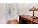Hallway featuring hardwood floors, a desk with a lamp, and a glimpse into the laundry room at 1528 Anthology Dr, Durham, NC 27703