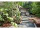 Exterior back of home with stone stairway, hot tub and mature trees at 1604 Pinecrest Rd, Durham, NC 27705