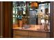 Elegant bar area with marble countertops, glass shelves, and mirrored backsplash at 1604 Pinecrest Rd, Durham, NC 27705