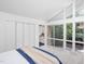 Bright bedroom featuring large windows, a walk-in closet, and view into the ensuite bathroom at 1604 Pinecrest Rd, Durham, NC 27705